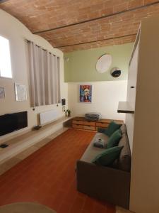 ein Wohnzimmer mit einem Sofa und einem TV in der Unterkunft Baccio - studio apartment in Montelupo Fiorentino