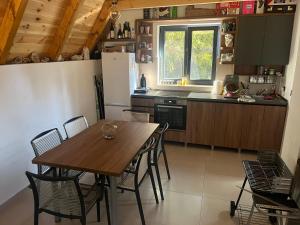 eine Küche mit einem Tisch und Stühlen sowie einem Kühlschrank in der Unterkunft Eden in Žabljak