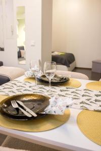 uma mesa com dois pratos e taças de vinho em Orchid&Sakura studios Kamppi em Helsinque