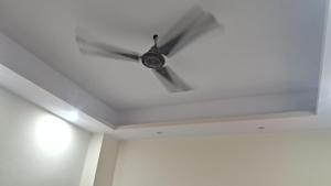 un ventilador de techo en una habitación con techo blanco en Laxman Guest House varanasi, en Varanasi