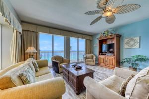 a living room with a couch and chairs and a television at Calypso Resort & Towers in Panama City Beach
