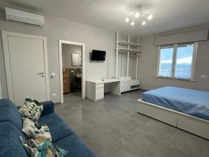 een slaapkamer met een bed en een blauwe bank bij Bcube - santa Bona Bed & Breakfast in Pisa