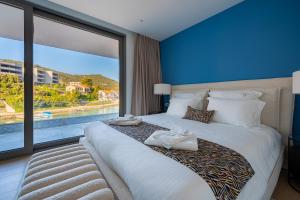 una camera da letto con un letto grande con una grande finestra di Villa Diva Korčula a Korčula Altre 102 foto