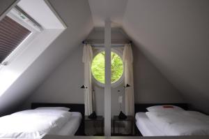 a attic room with two beds and a window at Hotel Village in Worpswede