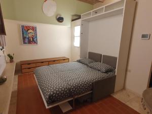 ein Schlafzimmer mit einem Bett in einem Zimmer in der Unterkunft Baccio - studio apartment in Montelupo Fiorentino