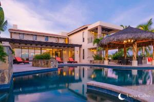 a swimming pool in front of a house at Firepit Sunsets, Hot Tub Soaks, BBQ, Ocean Views in San José del Cabo