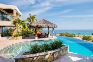 a villa with a swimming pool and the ocean at Firepit Sunsets, Hot Tub Soaks, BBQ, Ocean Views in San José del Cabo
