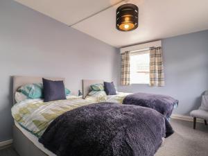 um quarto com uma cama grande e cobertores roxos em The Upper Circle em Clacton-on-Sea