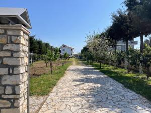 a cobblestone road in a vineyard with trees at Garden Villa Sunny in Tale