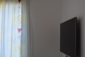 a flat screen tv next to a curtain with hearts at Garden Villa Sunny in Tale