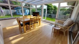 a screened in porch with a wooden table and chairs at Tradewind, Easton Lane, Freshwater in Freshwater