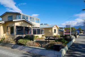 a yellow house with a picnic table in front of it at Sea View Motel - Unit 6 in Kaikoura