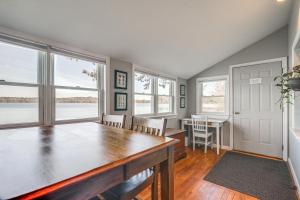 a dining room with a table and some windows at Quiet Plymouth Cottage on Great South Pond! in Plymouth