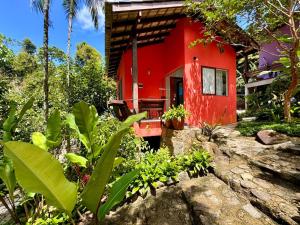 uma casa vermelha no meio de um jardim em Pousada do Riacho Trindade em Trindade