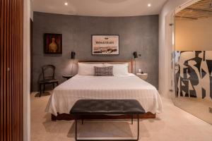 um quarto com uma cama grande e uma cadeira em Punta Majahua - Beach Front Villas em La Majahua
