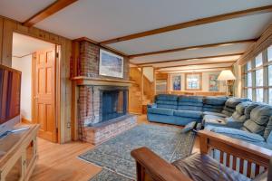 a living room with a blue couch and a fireplace at North Conway Home Less Than Walk to Slopes at Cranmore! in North Conway