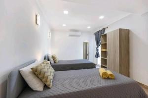 a bedroom with two beds with yellow slippers on it at Casa Serra e Mar in Luz +18 photos