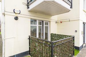 a white house with a black fence at Holywell Rise Swords in Swords