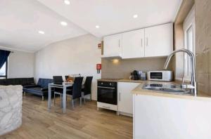 a kitchen and living room with a table and a couch at Casa Serra e Mar in Luz