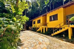 a yellow house with a walkway in front of it at Pousada do Riacho Trindade in Trindade