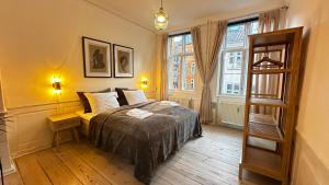 1 dormitorio con 1 cama y 2 ventanas en The Square - Apartments 1 & 2 - Carolinas Apartment en Copenhague