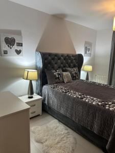 een slaapkamer met een zwart bed met 2 lampen en een tapijt bij La Cascade 1 in Oran
