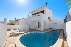 a swimming pool in front of a white house at Casa Serra e Mar in Luz