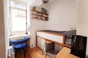 Schlafzimmer mit einem Schreibtisch und einem Bett mit einem Fenster in der Unterkunft Charming apartment in Nantes in Nantes