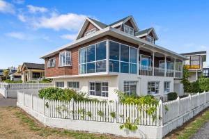 une grande maison blanche avec une clôture blanche dans l'établissement Fletcher House. No 1, à Taupo