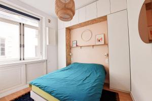 ein kleines Schlafzimmer mit einem Bett und einem Fenster in der Unterkunft Charming apartment in Nantes in Nantes