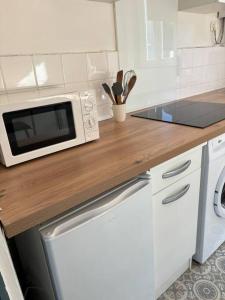a kitchen with a microwave on a wooden counter top at Soleil urbain in Périgueux