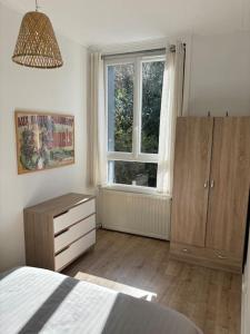 a bedroom with a bed and a dresser and a window at Soleil urbain in Périgueux