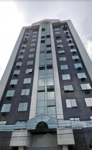 een hoog gebouw met veel ramen bij Studio central com Garagem in Pelotas