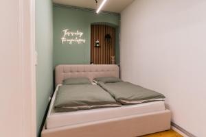 Cama en habitación con pared verde en bevoflats - Zentrales Apartment im Bergmannkiez, en Berlín