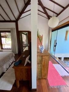 um quarto com uma cama e uma mesa com uma mesa de sidx em Blue House na Mata em Maraú