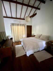 um quarto com uma cama branca e uma janela em Blue House na Mata em Marau