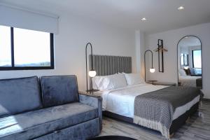 a hotel room with a bed and a couch at Hotel Villa Del Sol in Marquetalia