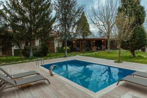 a swimming pool with two chairs next to a house at ALEX VİLLAGE LİFE in Kartepe