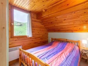 a bedroom with a bed in a log cabin at Chalet Peyragudes, 4 pièces, 6 personnes - FR-1-695-38 in Germ