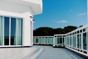 balcón de un edificio con ventanas de cristal y cielo azul en ST Beach Villa, en Kibweni