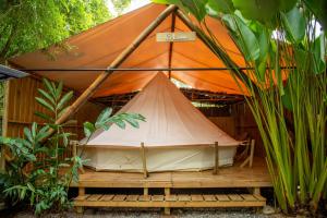 ein Zelt auf einer hölzernen Plattform in einem Garten in der Unterkunft Seren Glamping in Uvita