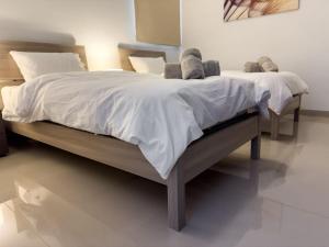 - une chambre dotée d'un grand lit avec des draps et des oreillers blancs dans l'établissement Hillcrest 3 Bedroom Apartment, à Mellieħa
