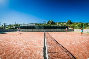 three people playing tennis on a tennis court at Golden Sea View in Sveti Vlas