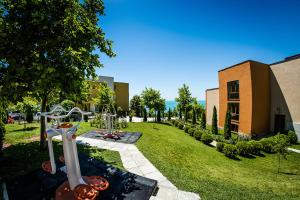 een tuin met een gebouw en een speeltuin bij Golden Sea View in Sveti Vlas
