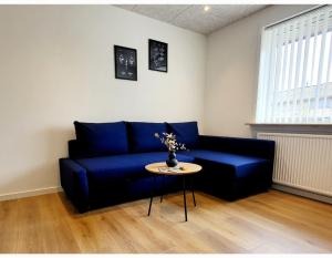 a blue couch in a living room with a table at Lego Fans Аpartment #1 in Billund Center in Billund