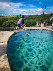 une personne jouant avec un ballon de football dans une piscine dans l'établissement Hacienda Los Molinos Boutique Hotel & Villas, à Boquete