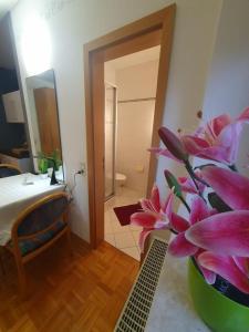 a vase with pink flowers on a table in a room at 5 Apartments bis 10 Personen in Zwingenberg