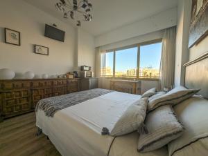 una camera da letto con un grande letto con cuscini sopra di Habitación privada en el centro ad Albacete