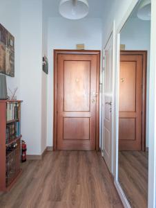 einen leeren Flur mit zwei Holztüren und Holzböden in der Unterkunft Habitación privada en el centro in Albacete