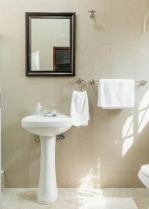 uma casa de banho com lavatório, espelho e toalhas em BlueGreen GuestHouse em Accra